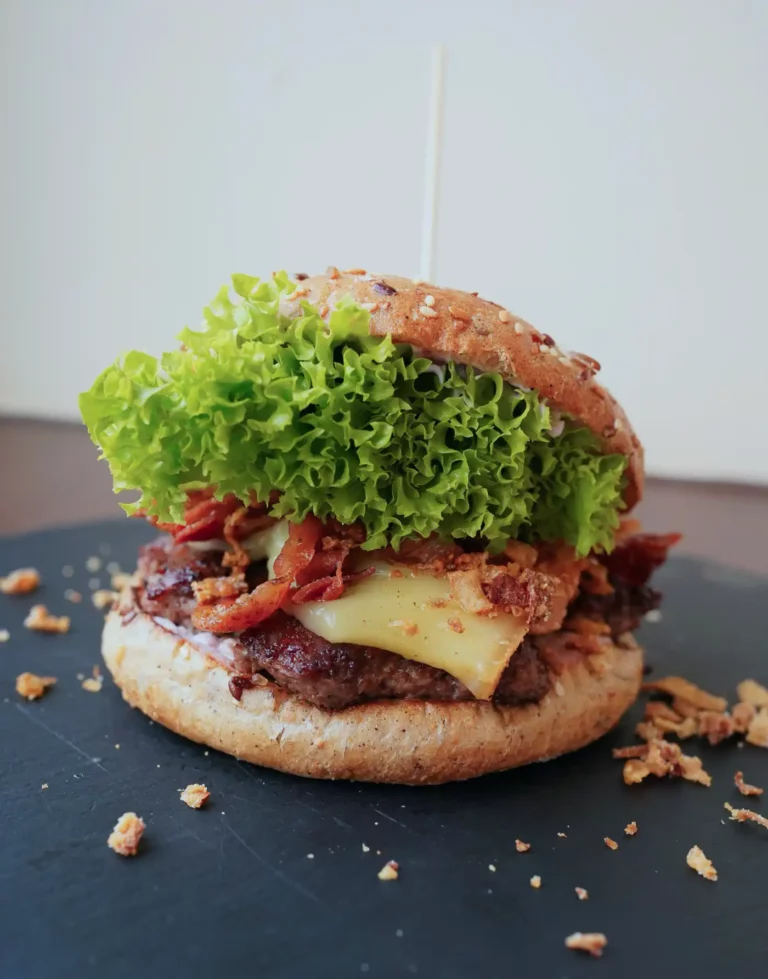 Der Burger des Monats Franzi + Kilian setzt sich zusammen aus Rindfleisch, Raclettekäse, Bacon, Röstzwiebeln, Schmand-Preiselbeer-Soße und Salat.